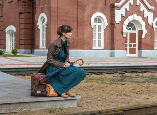 young woman waiting for train at station